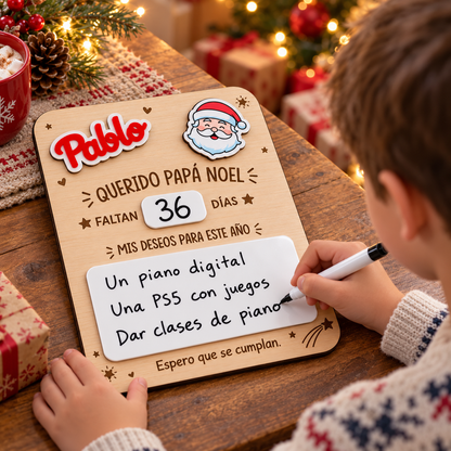Simulación: niño escribiendo sus deseos en el panel blanco de una placa navideña de Papá Noel.